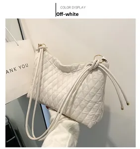 Detailed shot of a beige quilted shoulder bag featuring soft texture and drawstring strap