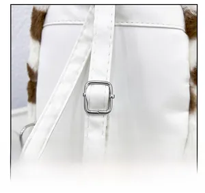 Détail des bretelles réglables en cuir blanc avec boucles sur sac à dos vache