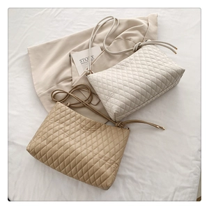 Close-up of quilted diamond pattern and drawstring strap with golden metal tips on handbags
