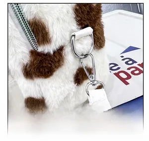 Détail d'un sac à dos en peluche à motif vache avec anneau en D et sangle en cuir