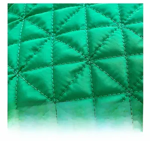 Macro shot of bright green quilted fabric with a detailed triangular stitching pattern