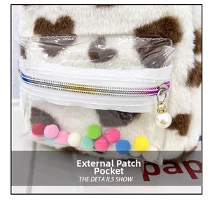 Détail d'un sac à dos en peluche avec poche extérieure transparente et pompons colorés