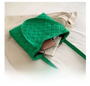 Internal view of green quilted tote bag showing large capacity for wallet and magazine