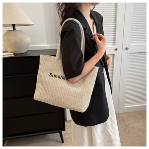 Detail of light beige woven tote bag with Sunshine print in a modern interior setting