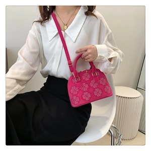 Détail du sac coquille en daim rose fuchsia avec strass floraux blancs et fermeture éclair dorée