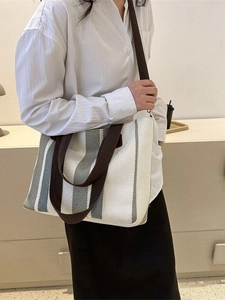 Vertical striped canvas tote bag for women with brown shoulder straps in a minimalist style