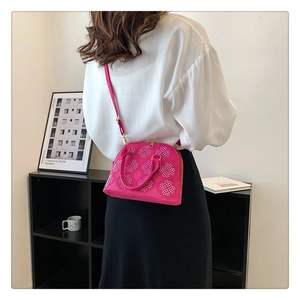 Vue détaillée d'un sac coquille rose avec motifs floraux et fine bandoulière amovible