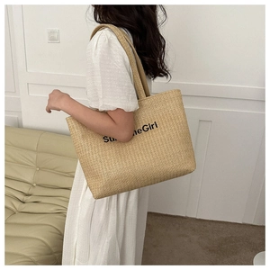 Detail of woven canvas tote bag featuring Sunshine Girl text worn by a model