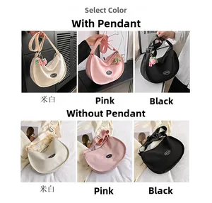 Detail view of crescent canvas crossbody bags in off-white, pink, and black colors