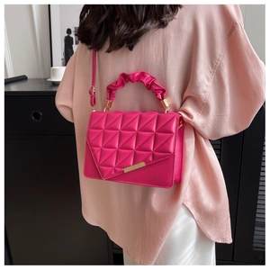 Détail du sac bandoulière fuchsia matelassé avec garniture dorée et poignée plissée