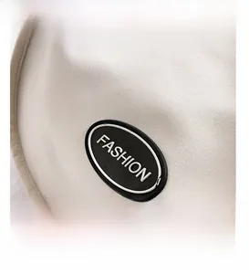 Detailed macro view of the cream white canvas fabric texture and black fashion logo badge