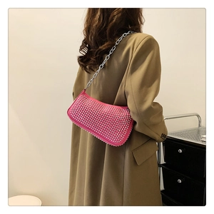 Detailed side view of pink studded baguette bag with silver chain strap on model