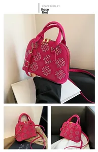 Vues détaillées d'un sac coquillage en daim rose rouge avec des motifs de clous en cœur