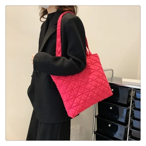 Macro shot of hot pink quilted tote bag with diamond texture and glossy finish