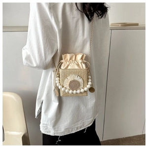 Straw mini bag detail with sunflower decor pearl handle and metal chain on model