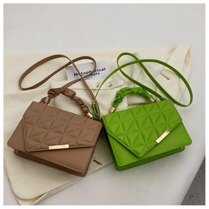 Détail du motif matelassé et des poignées froncées sur le sac à main marron et vert