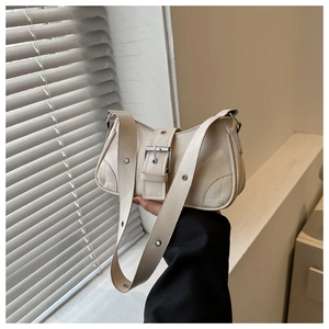Detail of cream shoulder bag with vintage buckle and silver studs on wide strap