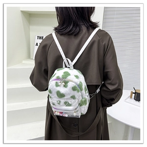 Détail d'un mini sac à dos en peluche à motifs cœurs avec poche frontale en PVC transparent