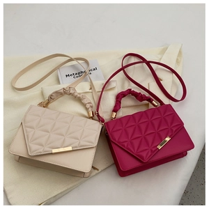 Détail de la texture matelassée et de la poignée froncée sur sacs crème et rose
