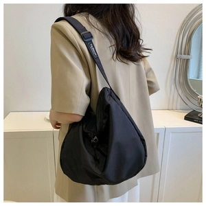 Détail du grand sac hobo noir avec logo Fashion sur la bandoulière portée
