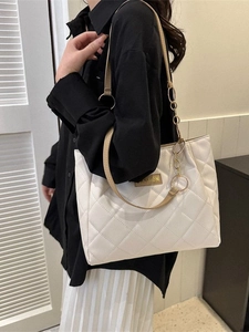Chic white quilted tote bag with brown straps and fashion plaque shown on a model