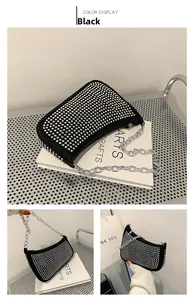 Detail of black rivet handbag with silver studs and chunky metal chain shoulder strap