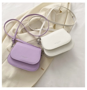 Detail view of purple and white PU leather saddle bags with Fashion Trend text engraving
