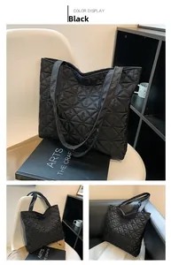 Detail of black quilted tote bag with star pattern stitching and long shoulder straps