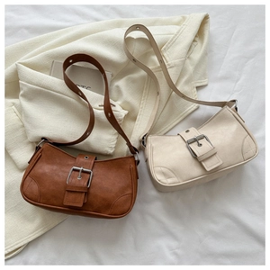Detailed close-up of vintage brown and cream shoulder bags with metal buckle accents