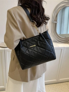 Women's black quilted tote bag with gold chain strap and elegant patchwork design