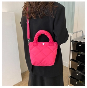 Detail of magenta quilted tote bag showing rhombus stitching and adjustable strap