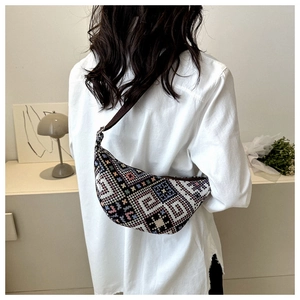 Détail d'un sac demi-lune tissé ethnique avec des motifs géométriques et une bandoulière