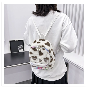 Vue arrière d'un mini sac à dos en peluche blanc avec motif cœur et détail de perles