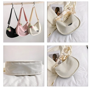 Detail view of crescent Hobo bag with nylon strap and cute knitted fruit charm accessory