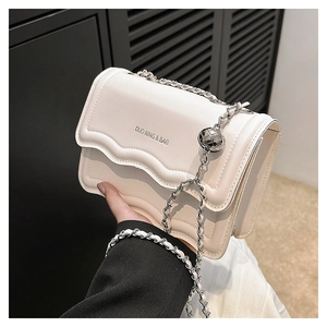 Detail of cream crossbody bag with wavy edge design and adjustable metal ball chain