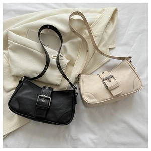 Flat lay of retro square shoulder bags in black and beige with buckle strap detail