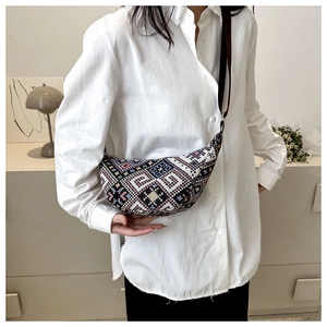 Détail d'un sac demi-lune bohème aux motifs géométriques tissés et losanges colorés