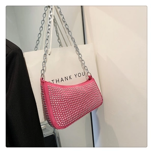 Detail of pink rivet shoulder bag with silver chain strap and metallic studs