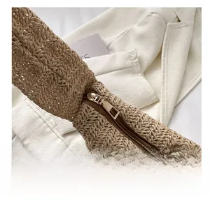 Close-up of smooth golden metal zipper detail on large capacity straw woven tote bag