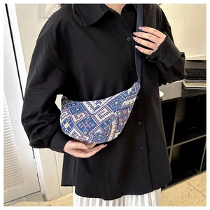 Détail du motif tissé ethnique sur le sac bandoulière en croissant porté par mannequin