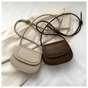 Close-up of beige and brown saddle bags with premium matte leather and fine stitching