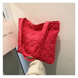 Detail view of rose red quilted tote bag featuring classic diamond stitching and nylon texture