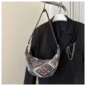 Gros plan détaillé du sac croissant tissé ethnique avec motifs géométriques colorés