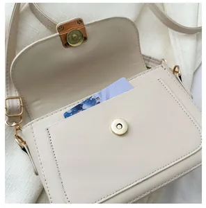 Close-up of beige PU leather shoulder bag featuring a functional front slip pocket