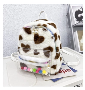 Vue détaillée du sac à dos en peluche avec motifs de cœurs et pendentif perle du zip