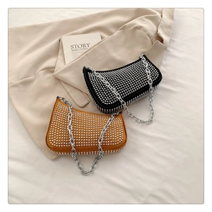 Detail of studded underarm bags in black and ginger yellow with silver chunky chains