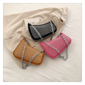 Three rivet crossbody bags in black, pink and yellow with silver chain straps and studs