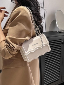 Chic beige chain bag with a stylish scallop wave flap and silver metallic strap