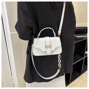 Detailed back view of model wearing white crossbody bag with acrylic chain and gold clasp
