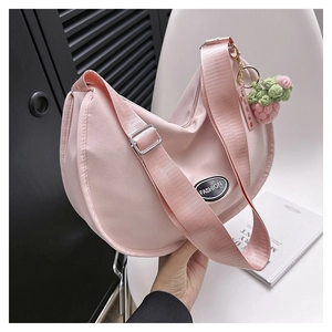 Pink nylon half-moon crossbody bag with wide strap and handmade strawberry charm
